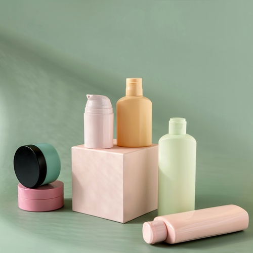 A selection of skincare product jars and bottles in different colors sit in front of a green background.