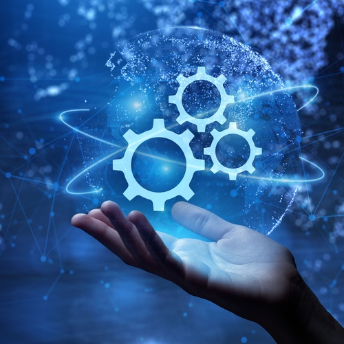 A hand holding up a hologram in a black void. The hologram shows a picture of three cog gears intertwined with each other.